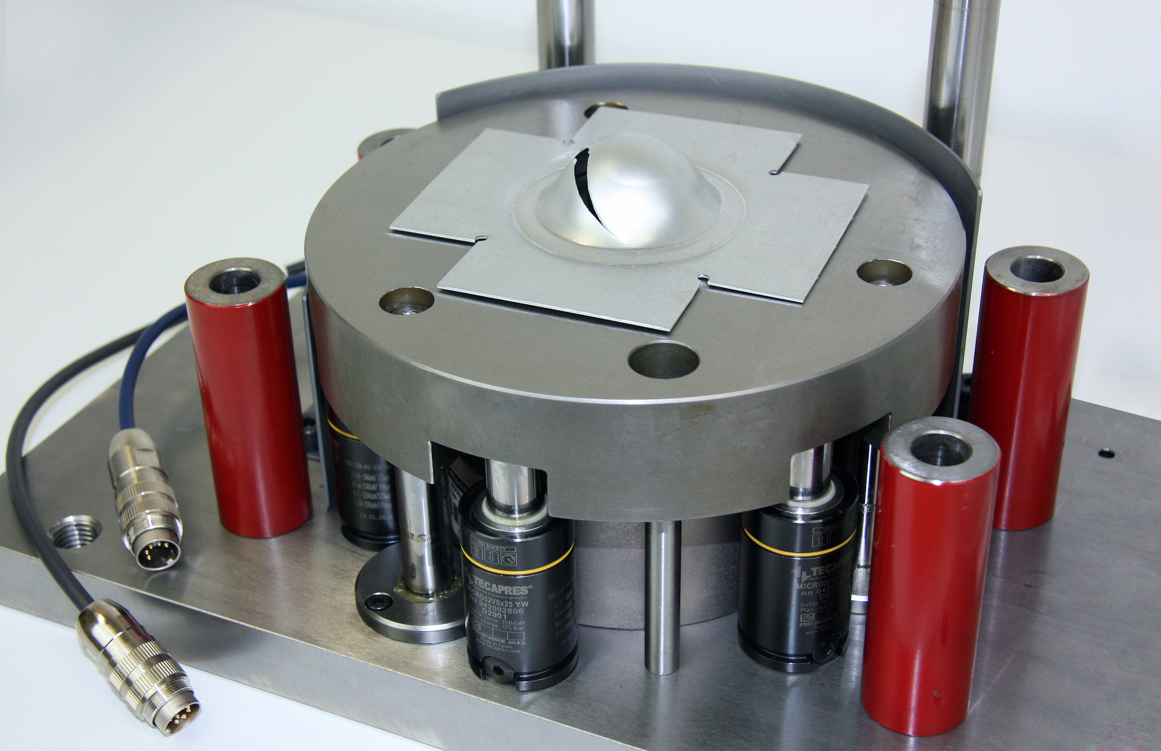 In der Prüfmaschine drückt ein halbkugelförmiger Stempel das Werkstück bis zu einer definierten Tiefe ein. Die Analyse des Kraft-Weg-Verlaufs erlaubt detaillierte Rückschlüsse auf die Qualität des Materials.