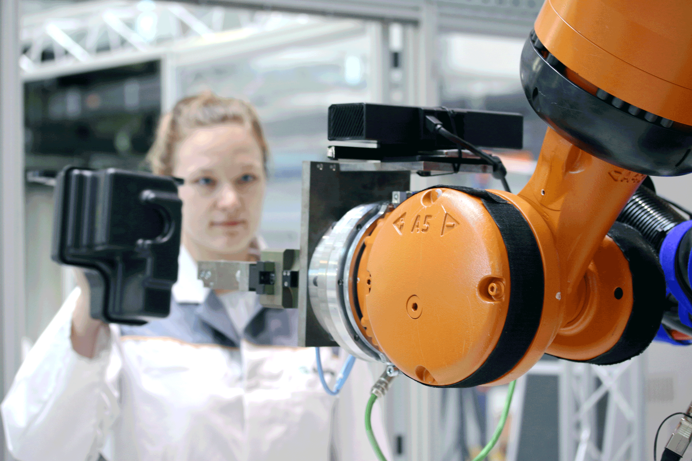 Der Roboter erkennt das Bauteil, das die Mitarbeiterin hält und folgt behutsam ihrer Hand bis zur Übergabe des Werkstücks.